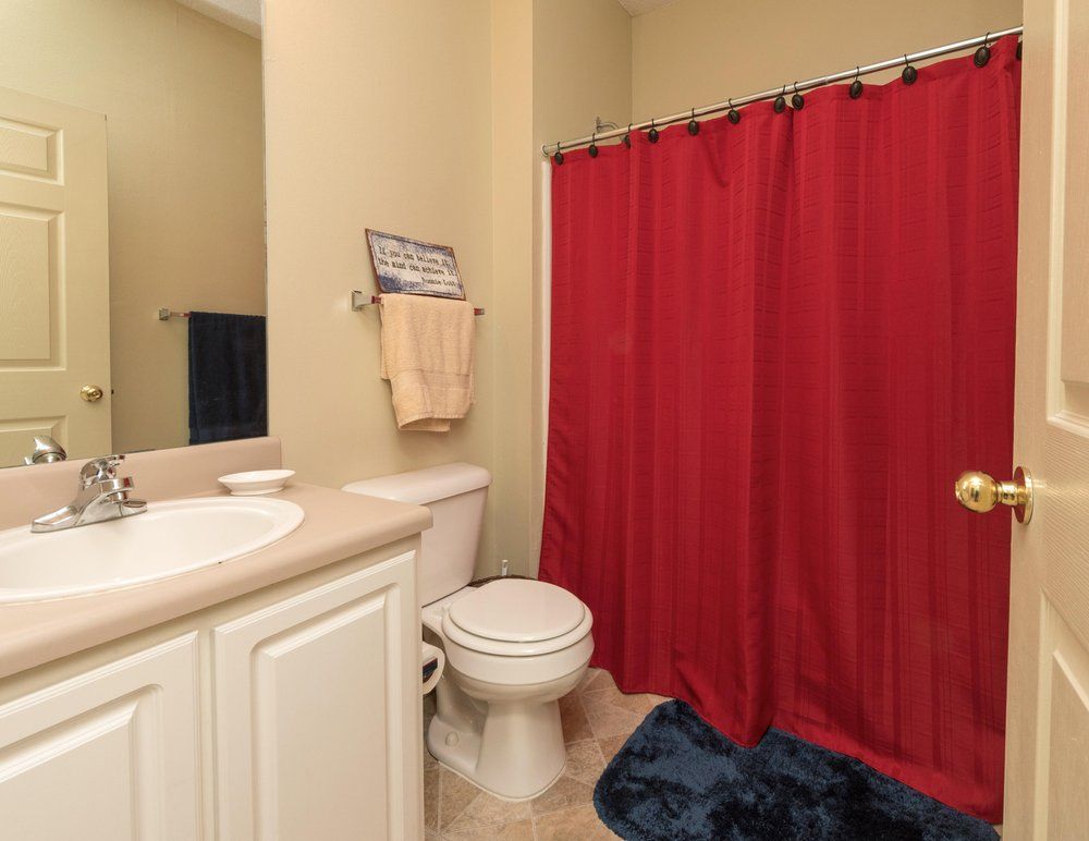 bathroom with red shower curtain